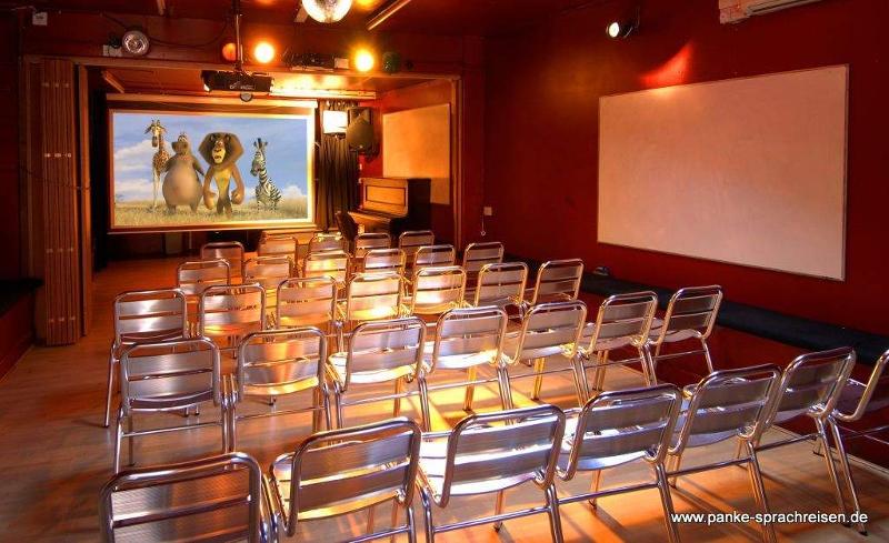 Sala de cine con proyector y multitud de sillas en el curso ingles en reino unido 