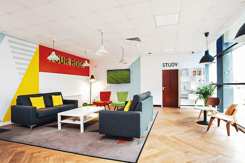 Sala de estar con sillas, cómodos sofás y televisión en la academia del curso verano inglaterra