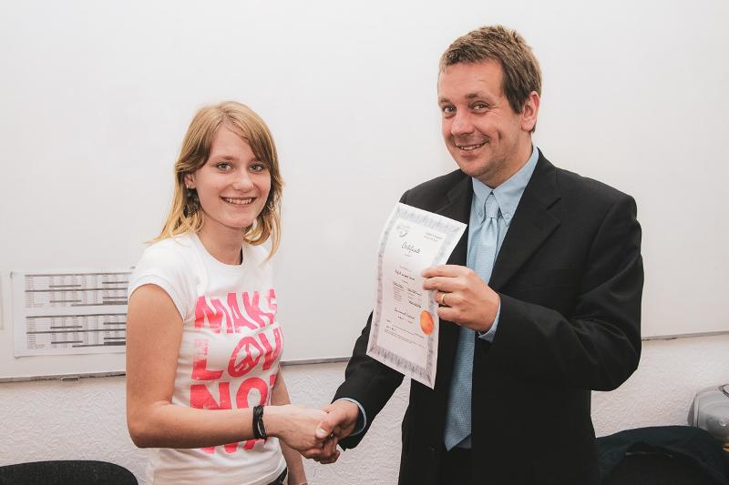 Profesor entregando un certificado de idiomas a su alumna en el curso ingles en reino unido