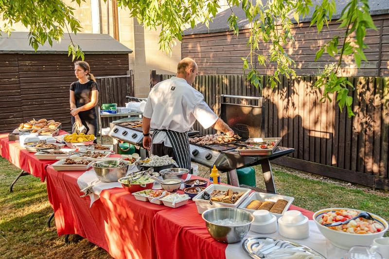 Barbacoa con una mesa repleta de distintos tipos de comida en el curso de ingles reino unido 