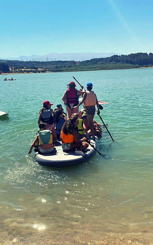 un grupo de jovenes en una canoa en el mar en un  campamento de verano jaen