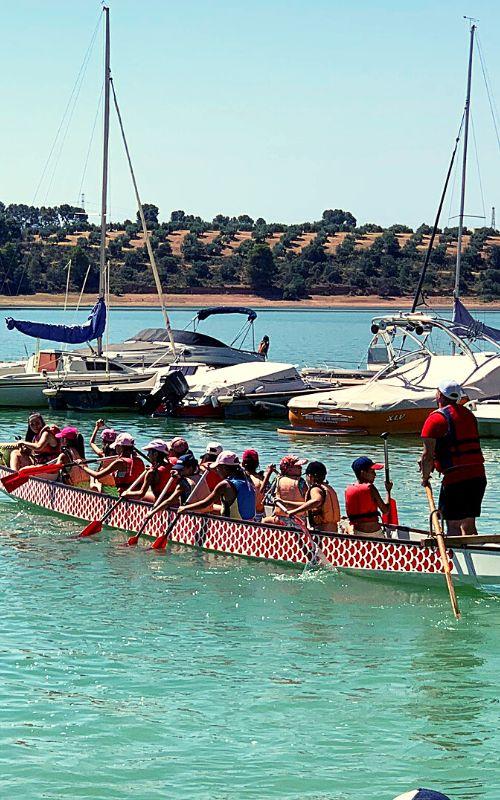 un barco dragon con varios niños encima en un  campamento de verano jaen