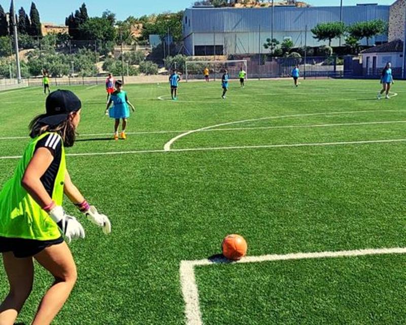 Niños jugando al futbol durante su participacion en un campamento tematico para niños