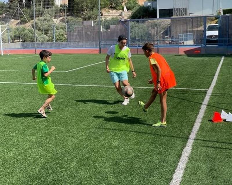 un grupo de niños jugando al fútbol en un campamento de verano jaen