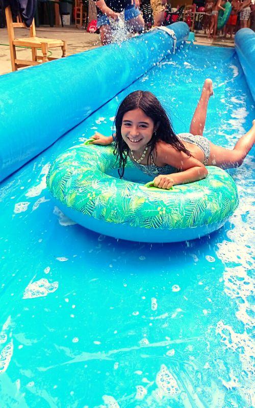 una niña con un flotador en un deslizador de un campamento de verano jaen