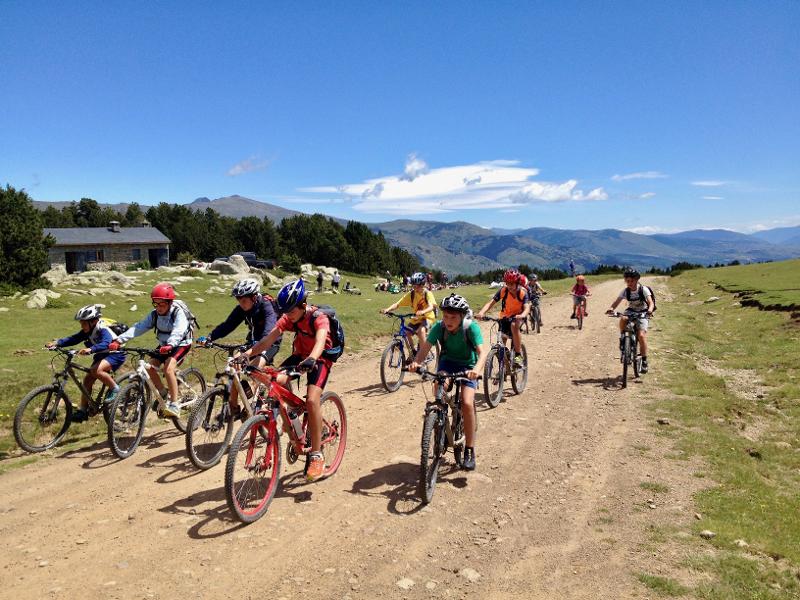 Un grupo de niños montando en bicicleta en un campamento multiaventura