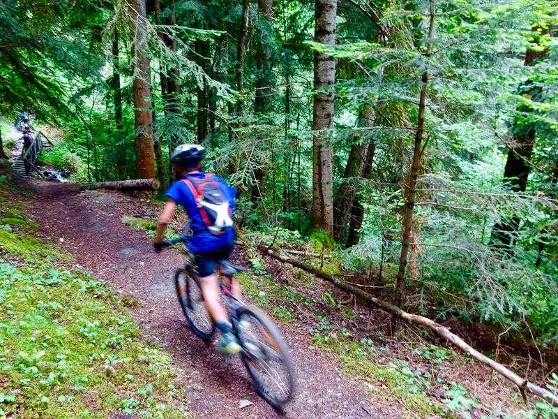 un niño montando en bicicleta en las montañas de un campamentos en pirineos