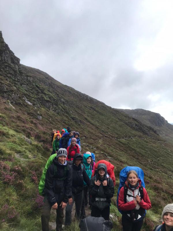 Jóvenes con sus mochilas haciendo senderismo en el campamento en irlanda