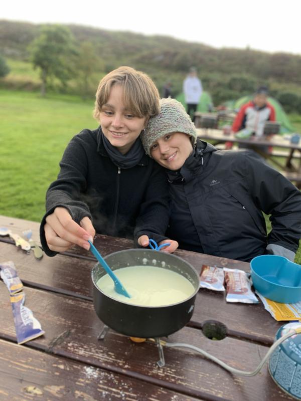 Jóvenes cocinando al aire libre en el campamento irlanda