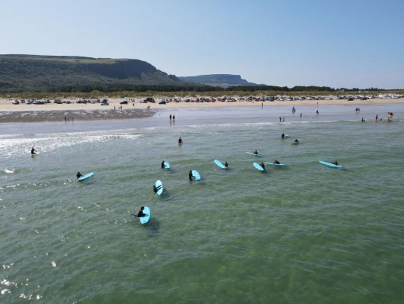 Jóvenes con sus tablas en el mar en el campamento irlanda