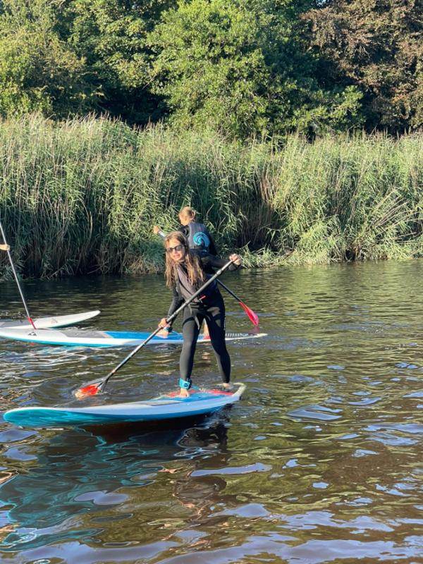 Jóvenes haciendo paddle surf en el campamento irlanda