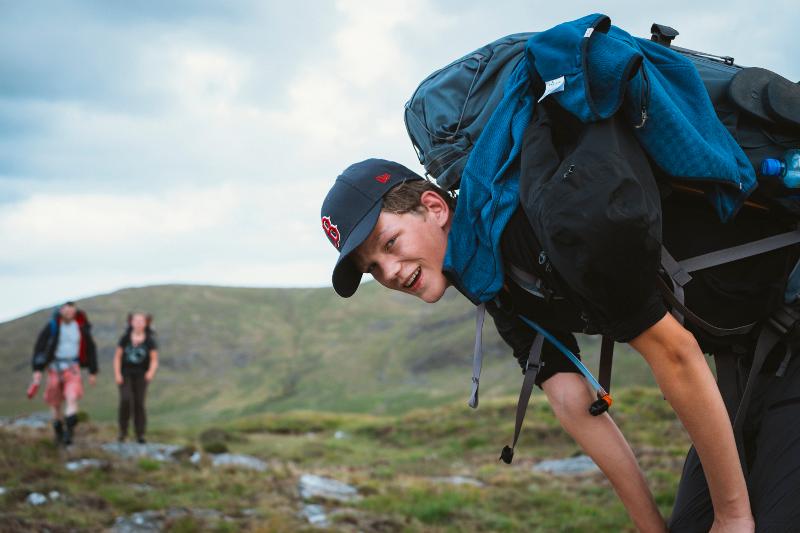 Chico con su mochila haciendo senderismo en el campamento de verano en irlanda