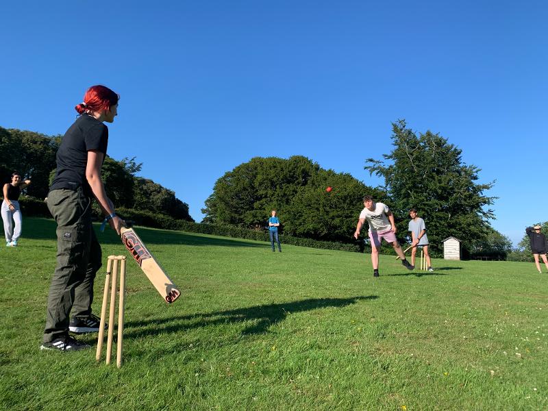 Jóvenes jugando al cricket al aire libre en el campamento de verano en irlanda
