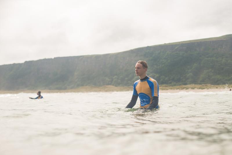 Chico con un neopreno en el agua en el campamento irlanda verano