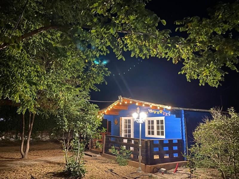 La vista de una casa azul por la noche en un campamento de verano