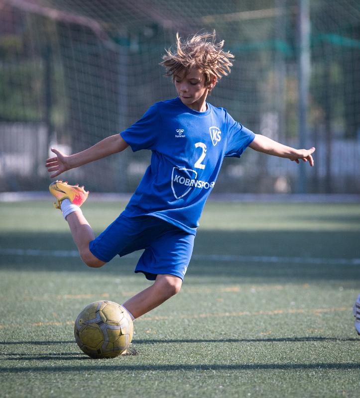 Un niño jugando al fútbol en un campamento de verano en valencia barato