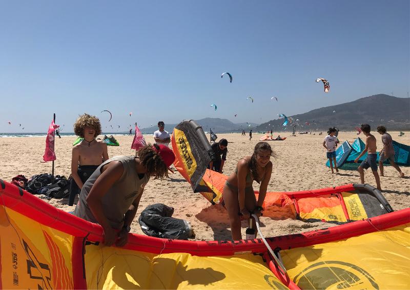 Niños preparándose para realizar kitesurf durante un campamento de verano en cadiz para niños