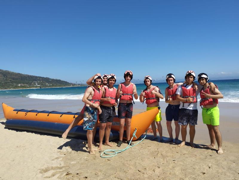 Un grupo de niños en una playa posando a cámara en un campamento multideporte