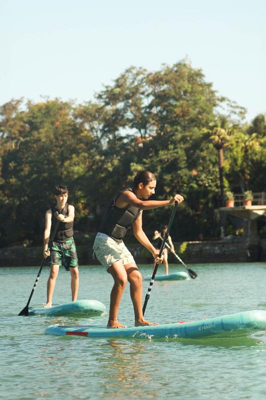 Niño realizando paddle surf en aguas tranquilas durante un campamento surf berria