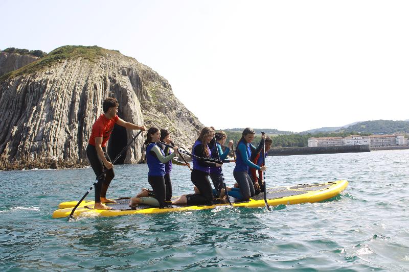 Un grupo de jovenes en una tabla en surfcamp pais vasco