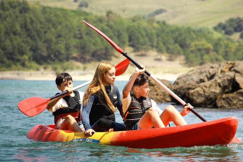 Niños con un kayak en un campamento ingles pais vasco