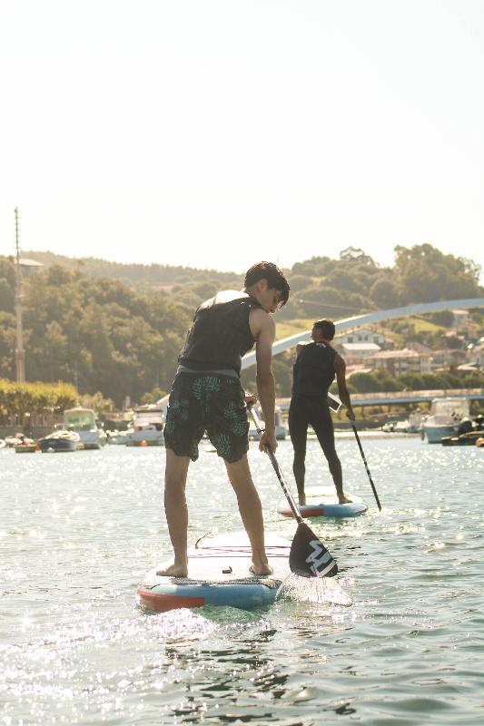 Dos chicos haciendo paddlesurf en un surfcamp pais vasco