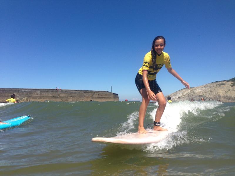 Una chica surfeando una ola en un surfcamp pais vasco