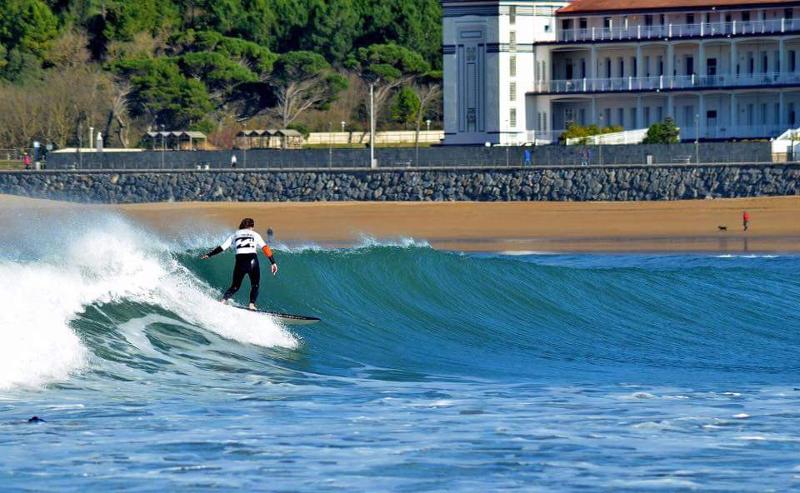 una chica cogiendo una ola en un surf camp pais vasco