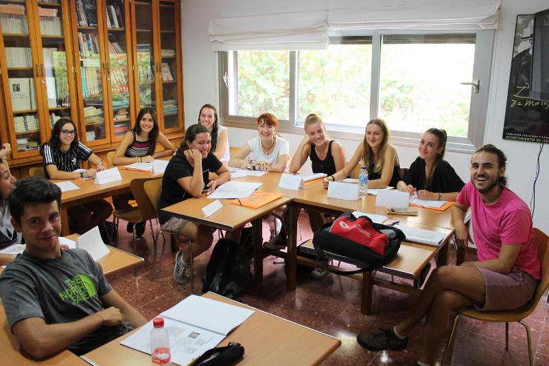 Jóvenes en el curso de idiomas en españa  en clase con su profesor