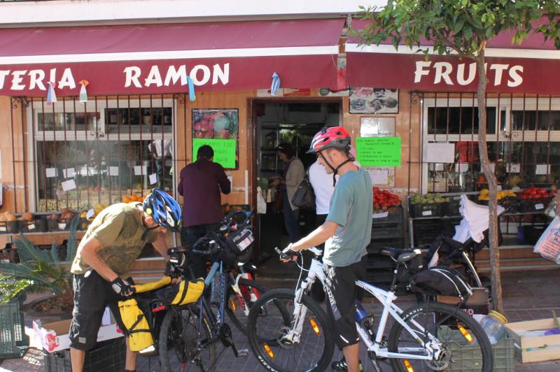 Frutería de Benalmádena con dos ciclistas en la puerta en el curso de idiomas en españa 