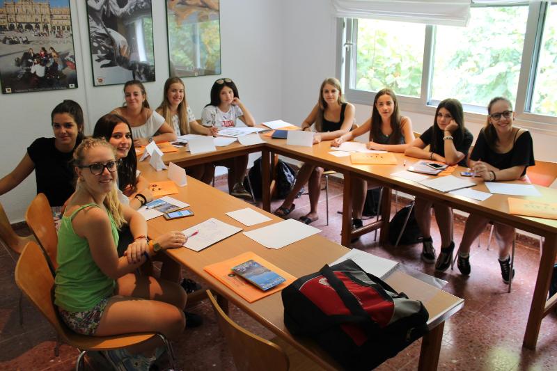 Chicas sentadas en sus pupitres en clase en el curso de idiomas en españa 