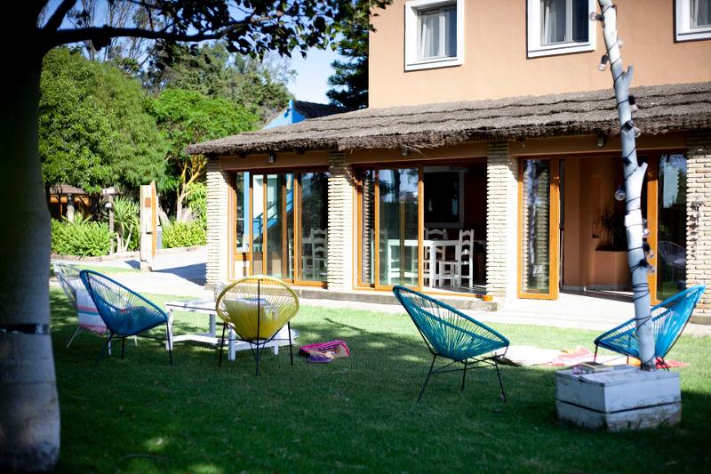 Jardín del alojamiento de un surf camp cadiz con sillas y mesas