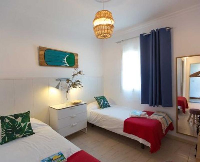 Habitación de doble con espejo y cómoda en un cadiz surf camp