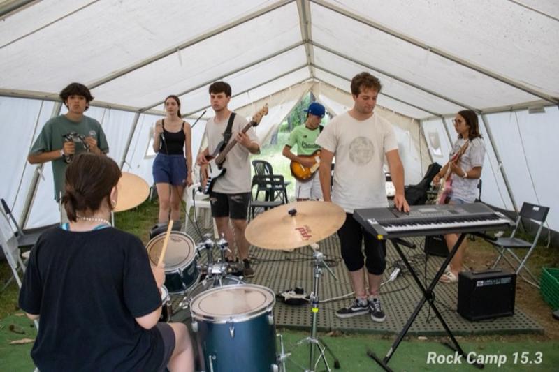 Un grupo de musica practicando en un campamento de musica en verano