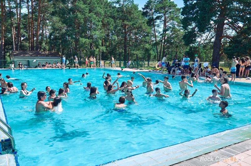 Un grupo de niños en una piscina en un campamento de verano musica