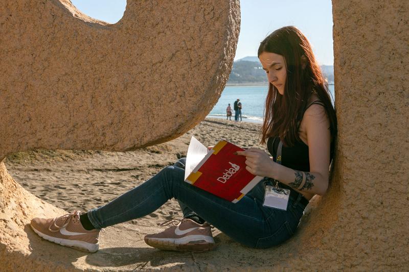 Chica leyendo en la playa en el curso de español españa