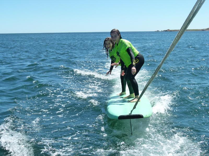 Dos chicas en una tabla surfeando durante el surf camp Galicia