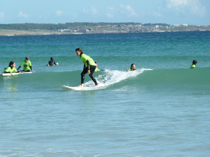 Chica joven surfeando en el surf camp Galicia