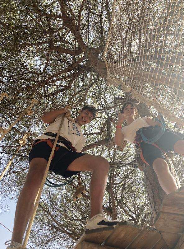 Dos jovenes jugando en un arbol en un campamento de verano cadiz