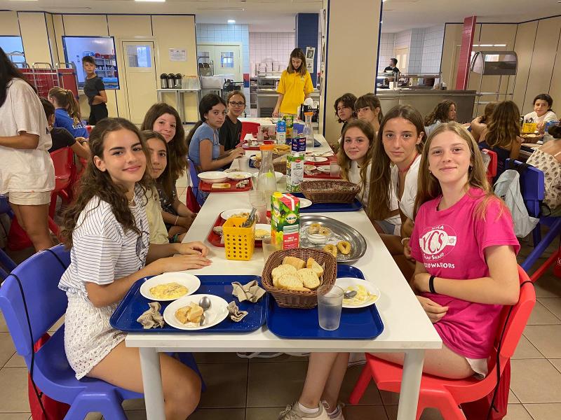 Un grupo de jovenes en una mesa desayunando en un campamento en cadiz