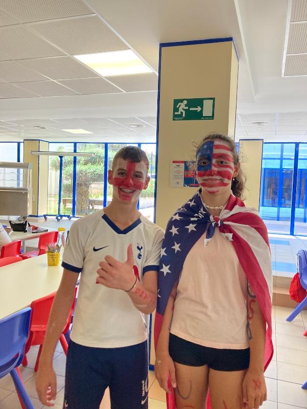 Dos jovenes disfrazados con la bandera de estados unidos en un campamento en cadiz