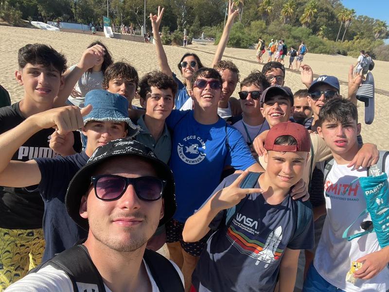 Una foto de un monitor con sus alumnos en un campamento en cadiz