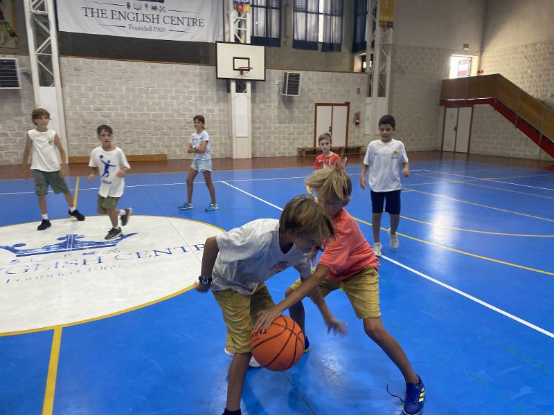 Un grupo de niños jugando al baloncesto en un campamento cadiz