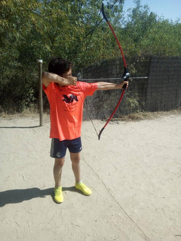 Un niño practicando tiro con arco en un campamento de futbol en madrid