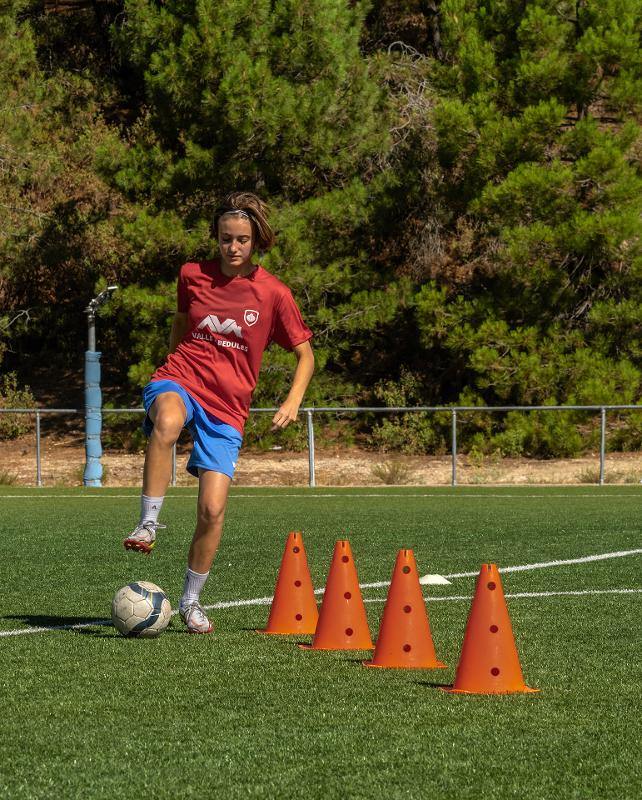 Una chica jugando al futbol en un campamento de futbol en madrid