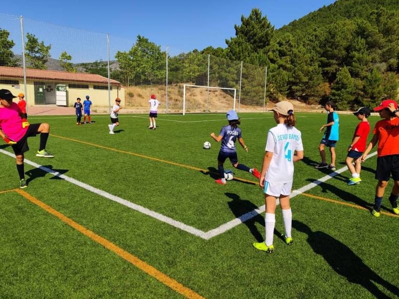 Un grupo de niños jugando al futbol en un campamento de futbol en madrid