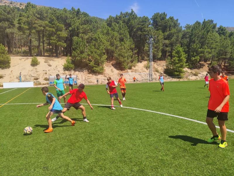 Niños jugando a un partido amistoso en un campamento de futbol en madrid