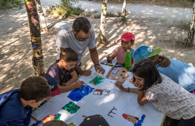 Niños pintando en una mesa en un bosque en un campamento de futbol en madrid