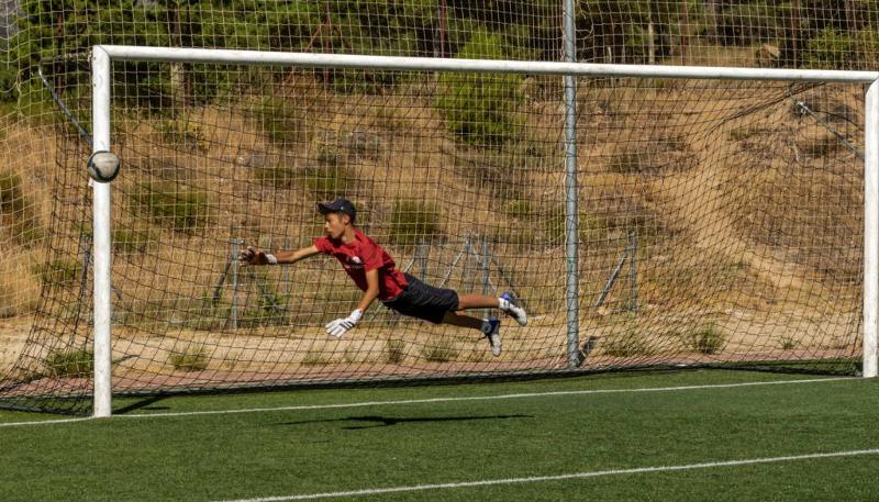 Un niño parando un gol en una porteria en un campamento de futbol en madrid