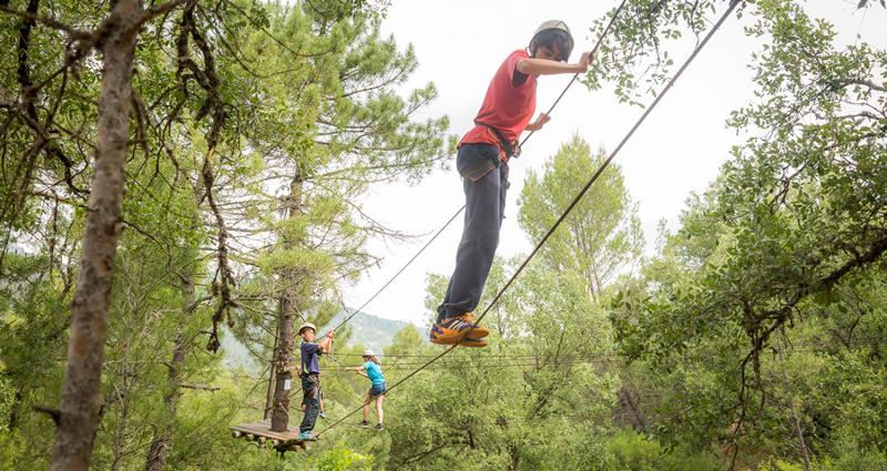 Descubre el slackline con tus amigos en un campamento jaen Un grupo de niños practicando slackline en un campamento jaen